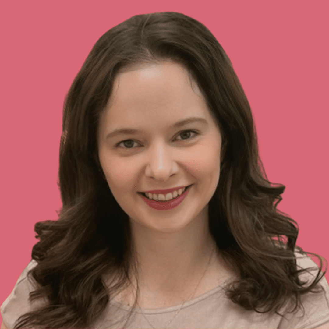 A woman with long brown hair smiles for the camera.