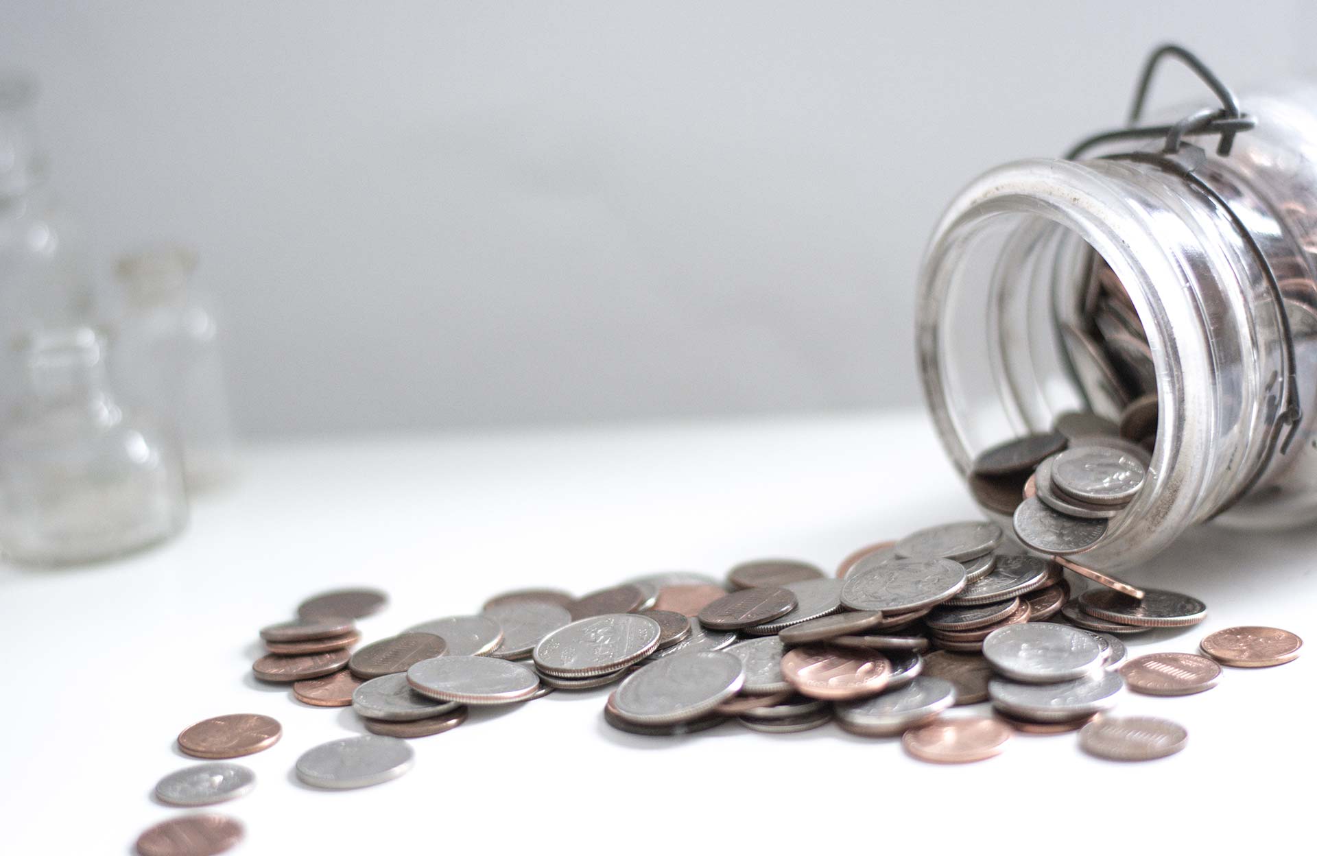 Spilled coins from a glass jar.